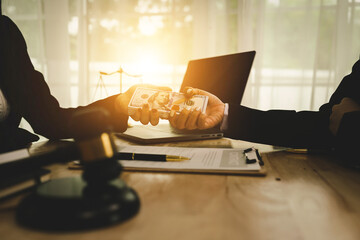 Two professionals are signing a legal agreement at a desk, with a judge’s gavel nearby. The scene reflects law, business contracts, and formal documentation.x