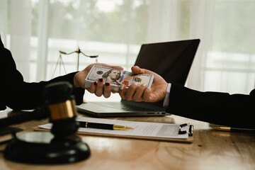 Two professionals are signing a legal agreement at a desk, with a judge’s gavel nearby. The scene reflects law, business contracts, and formal documentation.x