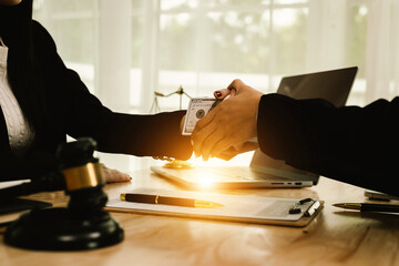 Two professionals are signing a legal agreement at a desk, with a judge’s gavel nearby. The scene reflects law, business contracts, and formal documentation.x