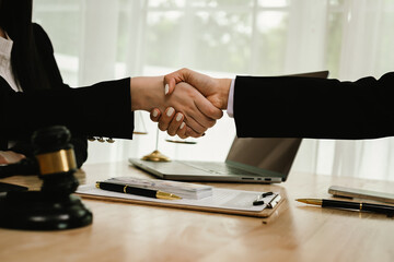 Two professionals are signing a legal agreement at a desk, with a judge’s gavel nearby. The scene reflects law, business contracts, and formal documentation.x