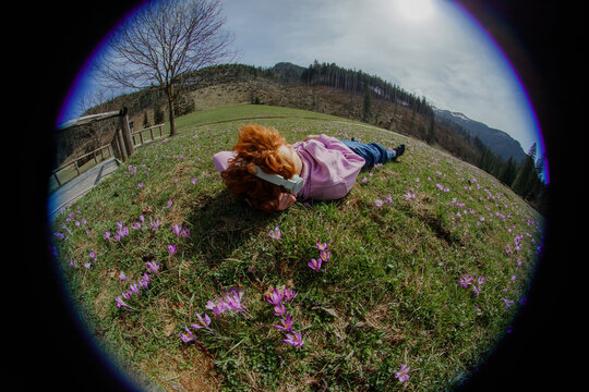 A person listens to music in a meadow with flowers