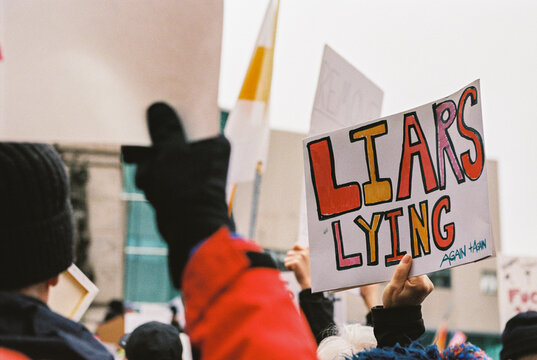 Protesters in Portland, Maine hold signs opposing policies