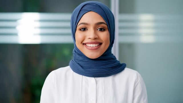 closeup headshot face portrait of young muslim specialist business lady in headscarf hijab in office