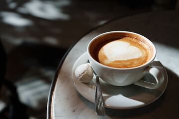 Warm coffee with heart latte art on a table
