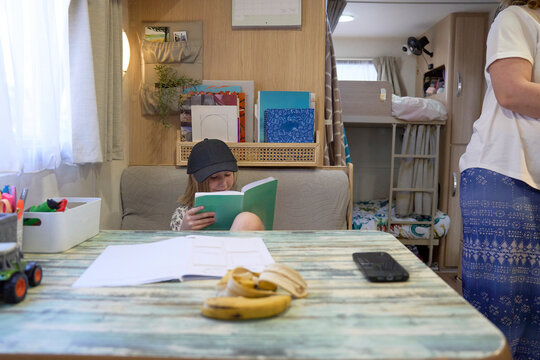 Child reading in caravan during homeschooling session 