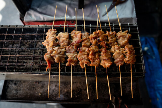 Pork on sticks, called Moo Ping, is grilled as street food in Bangkok