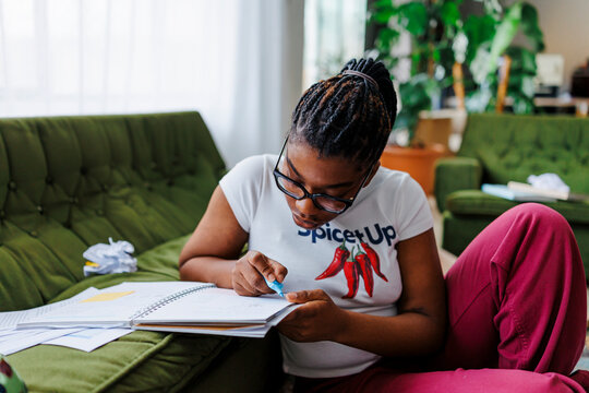Female student underline notes studying at home