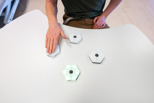 Man playing interactive game using hexagonal controllers