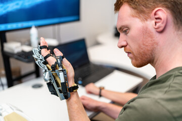 Engineer testing robotic hand prosthesis in laboratory