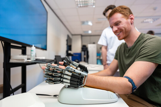 Patient testing robotic hand prosthesis in medical laboratory
