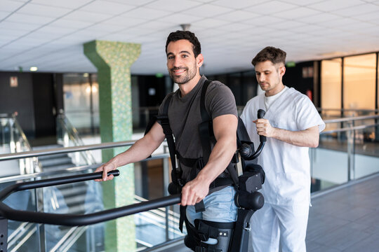 Physiotherapy assisting patient walking using exoskeleton