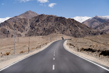 Van drives on a long, curvy road through the Himalayas in remote India