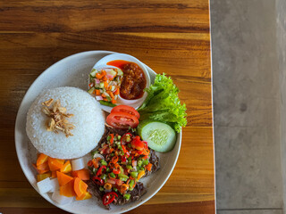 Spicy Indonesian Nasi Iga Bakar or grilled rib rice, pounded chili beef, vegetables, and condiments