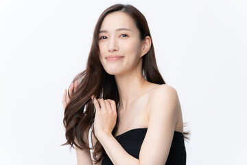 白バックでスキンケアをする若い女性
