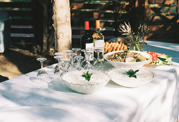 Elegant outdoor dining setup with wine, salads, and appetizers 