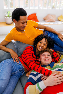 Happy friends relaxing and enjoying time together on sofa