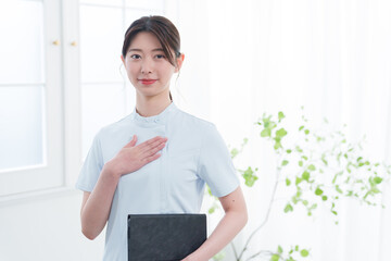 胸に手を当てる女性看護師