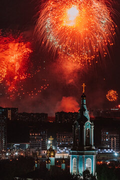 Fireworks illuminate the night sky over a city skyline