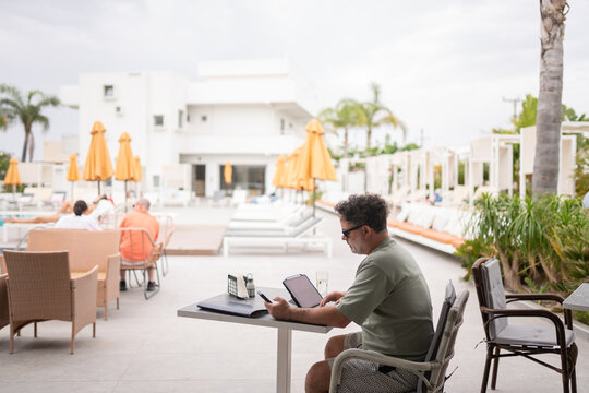 Businessman Working at Poolside Bar Terrace

 - Powered by Adobe