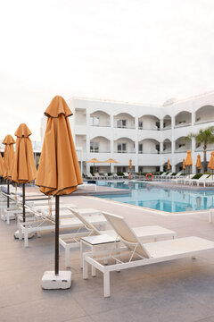 Empty Resort Pool Area with Deck Chairs and Umbrellas 