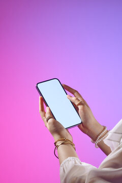 A woman holds a frameless mobile phone with blank screen