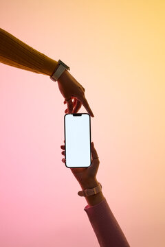 Two hands converge to interact with a blank smartphone screen