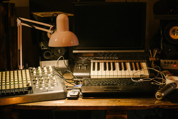 Music studio work space illuminated by warm incandescent light.