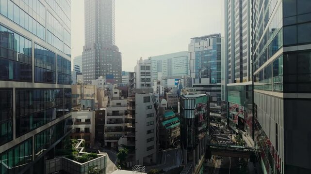 The drone flies between the houses of a modern city. Aerial view of Tokyo, Japan
