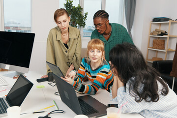 Young adult woman colleagues socializing and working together in a modern workplace, representing...