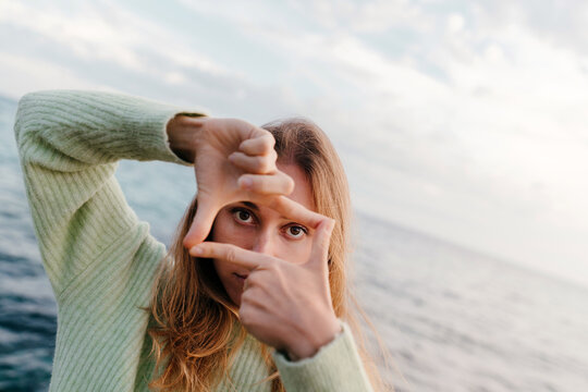 Portrait of young woman doing a frame gesture with her hands