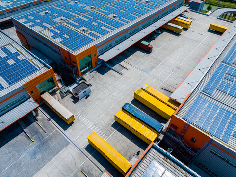 Aerial View of Factory with Solar Panels and Transport Trucks