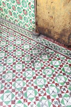 Green red floor tiles with weathered surface and dirt marks
