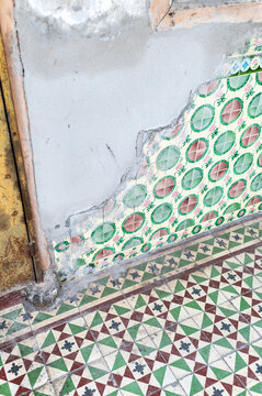 Broken colonial wall with floral tiles and textured layers
