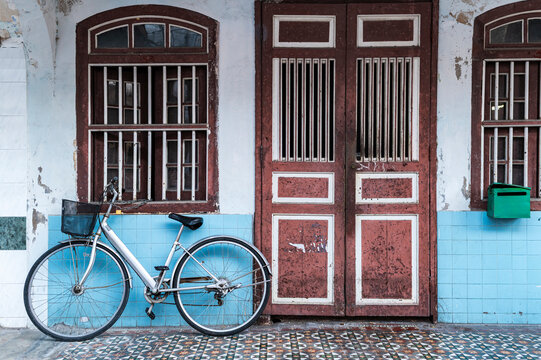 Red doors and bicycle in pastel colonial facade