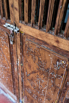 Carved wooden door with chipped varnish and lock detail 