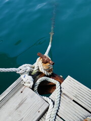 Rusty metal boat mooring post and old rope tied vertical photo