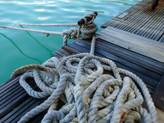 Rustic dock scene with old rope tied to rusty mooring post