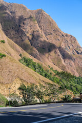 Winding mountain road in Sembalun, Lombok, leading toward Mount Rinjani National Park, surrounded...