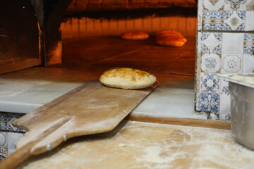 Warm bread baking in traditional oven at bakery