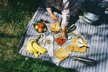 Unrecognizable girl lying on a picnic  blanket at summer.