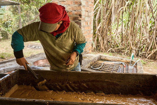 Latin american farmer making panela from sugar cane juice