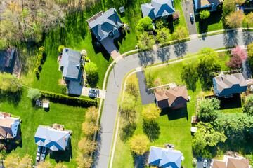 Suburban houses with green lawns curved street in East Brunswick, Middlesex County, New Jersey...