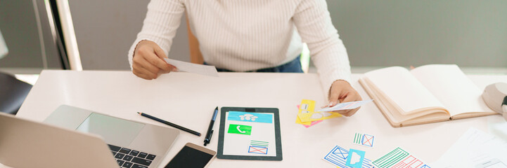 User Interface Designer Asian Woman Creating Mobile App Layout Hand Holding Paper Ideas Website Design Sketching UX Process on Table