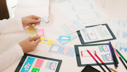 UI UX Designer Asian Woman Hands Creating Mobile App Wireframes on Desk with Colorful Pencils, Paper Prototypes for Website Design and User Interface Development
