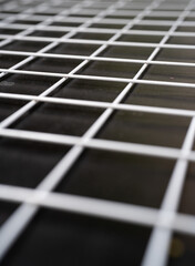 Close-up of a black surface with a white grid pattern.
