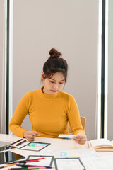 Asian Woman UI UX Designer Creating Mobile App Interface Layout and User Experience on Tablet. Web...
