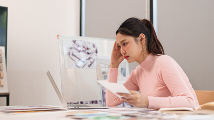 Stressed Asian UI UX Designer with Laptop Working on User Interface Design Project in Office...