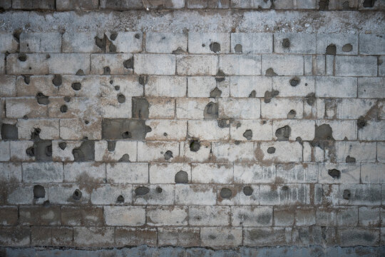 Fototapeta Wall with many gray holes