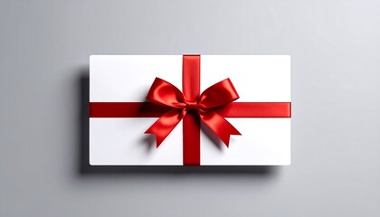 White gift box with red ribbon on grey.
