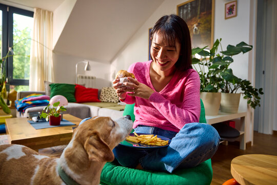 Woman shares her meal with a dog